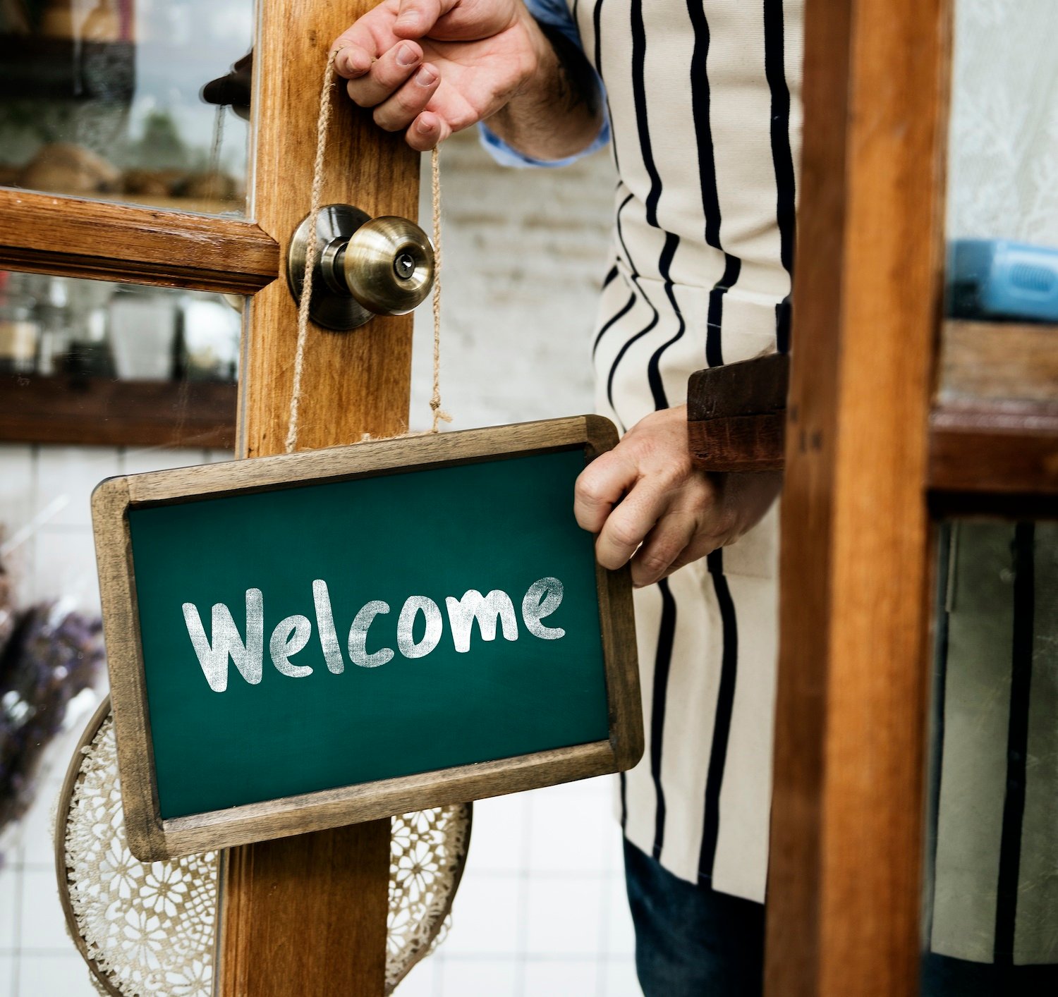 man putting welcome sign on the door